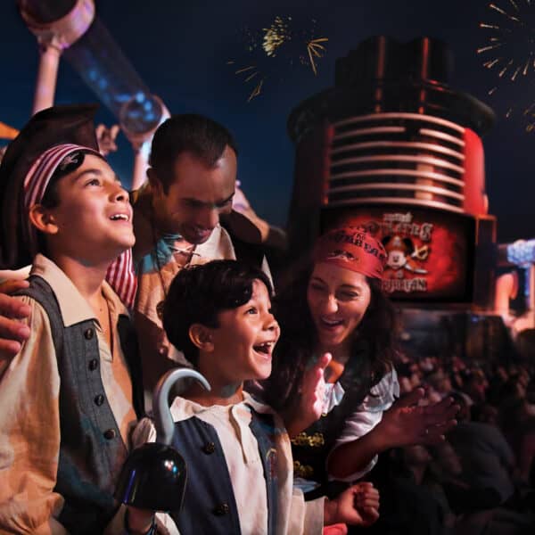 A family dressed a pirates smiling and enjoying Pirate night fireworks o