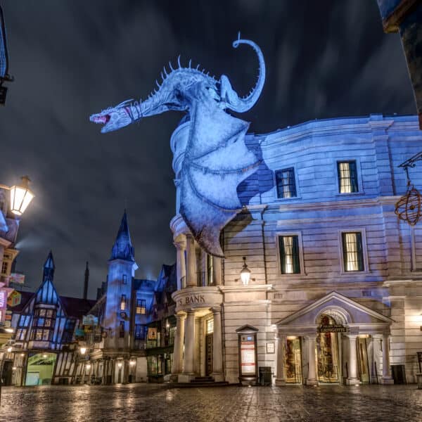 Nighttime empty street view of Diagon Alley and the entrance to Gringotts bank with the dragon perched on top of the building at Universal Studios Florida.