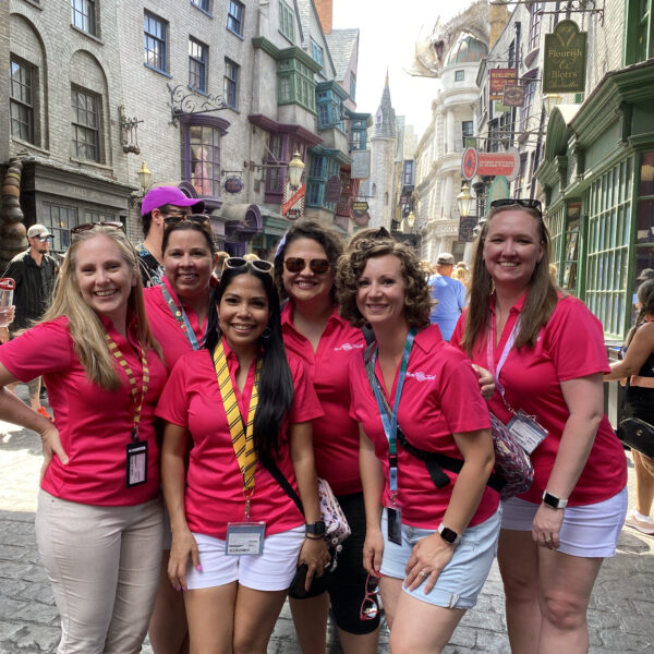 Mom Approved Travel Advisors pose for group picture in front of Universal Orlando Diagon Alley while on a Universal Trip