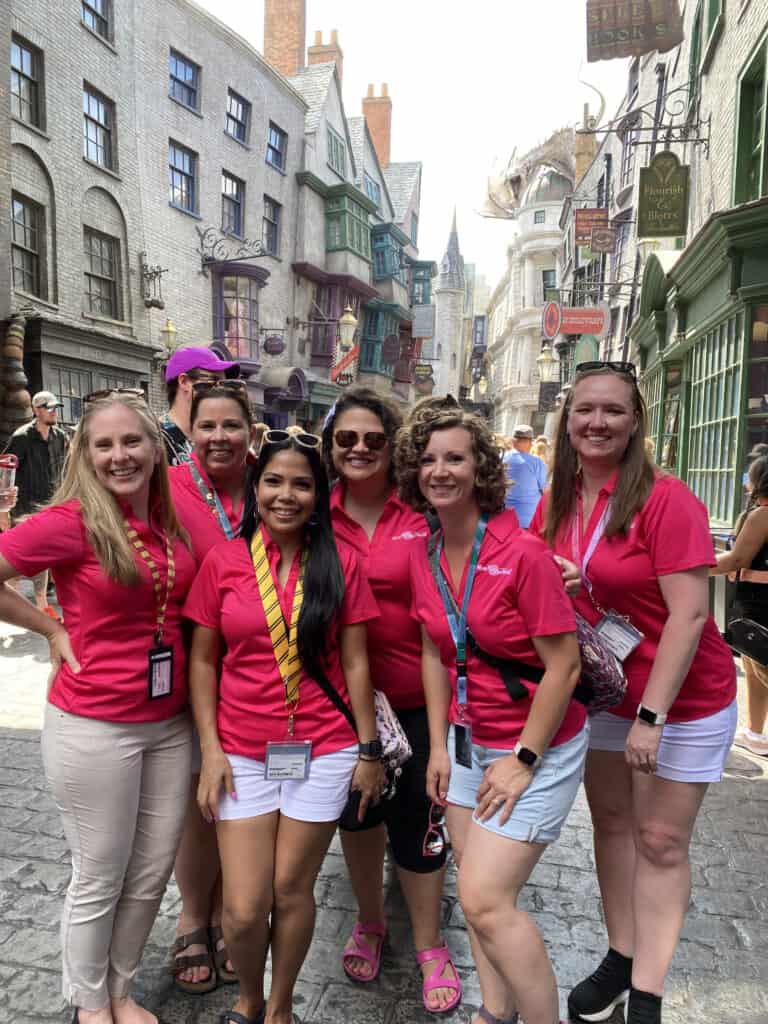 Mom Approved Travel Advisors pose for group picture in front of Universal Orlando Diagon Alley while on a Universal Trip