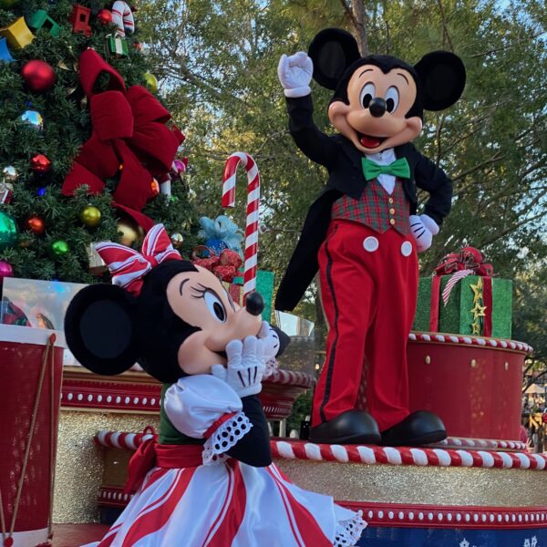 Mickey and Minnie Mouse dressed in Christmas attire waving to crowds at the Mickey's Very Merry Christmas Party Christmas parade in Magic Kingdom