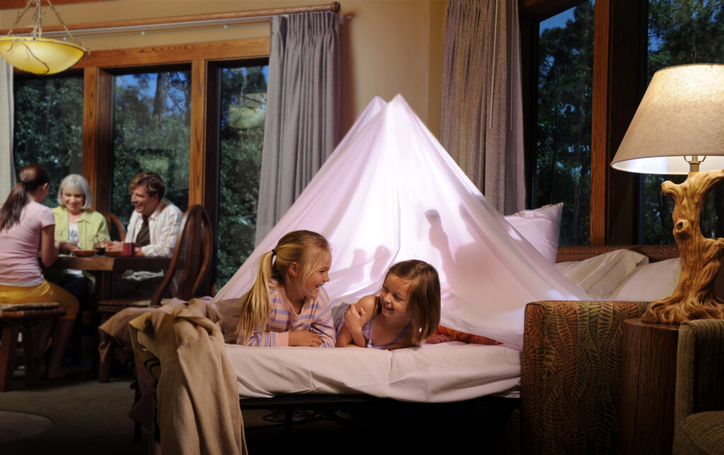 girls giggling under a tent made on sofa