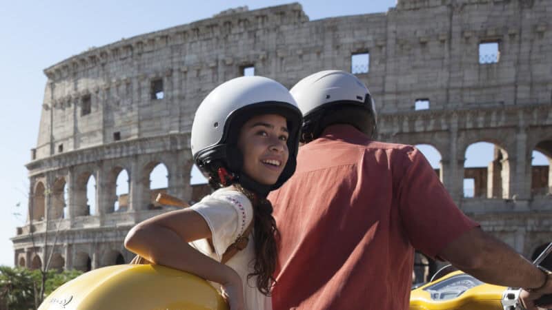 girl wearing helmet on bike with Rome in background