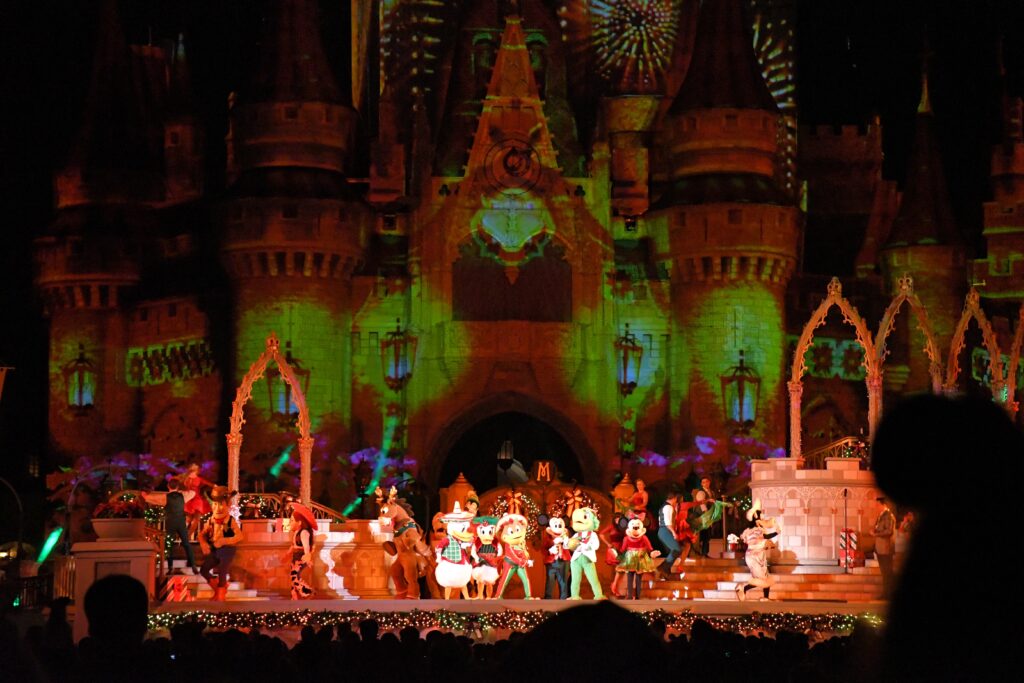 Disney Characters dancing on stage of the castle show at night during Mickey's Very Merry Christmas Party at Walt Disney World