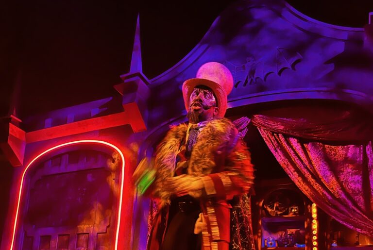 Scare actor performing on colorful lit stage during Halloween Horror Night at Universal Orlando