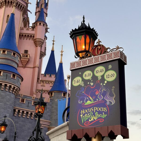 Image of the sign infront of Cinderella's castle in Magic Kingdom showing the times for the Hocus Pocus Villain Spectacular stage show offered during the MNSSHP Halloween party