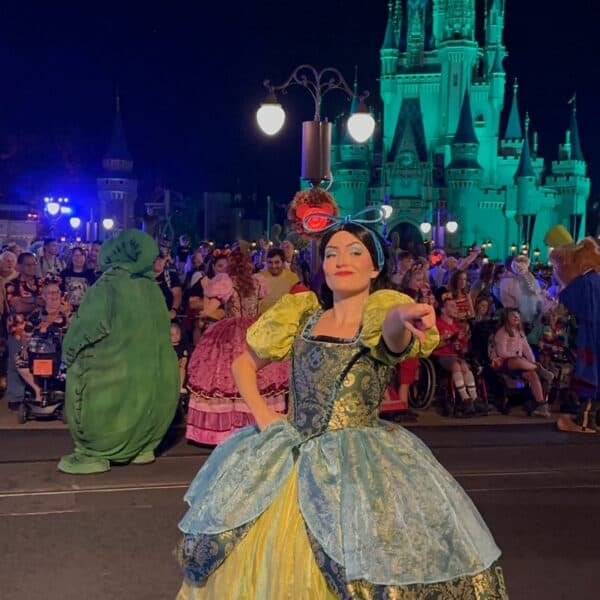 Disney Villain Drizella pointing to crowd along parade route at night during Mickey's Not So Scary Halloween Party parade at Walt Disney World