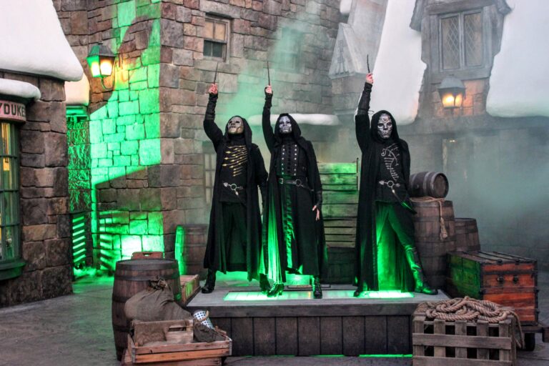 3 scare actors dressed as Death Eaters from Harry Potter on stage performing during Halloween Horror Nights