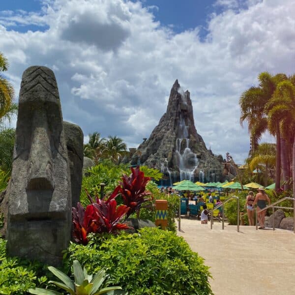 lush tropical entrance to pool area of Universal's Volcano Bay with Krakatau Volcano in background