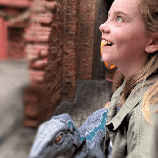 little girl looking woth awe through the walls of Diagon Alley at Universal Orlando