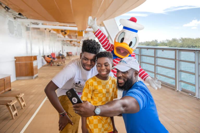 family taking pictures with Donald Duck on a Disney cruise ship